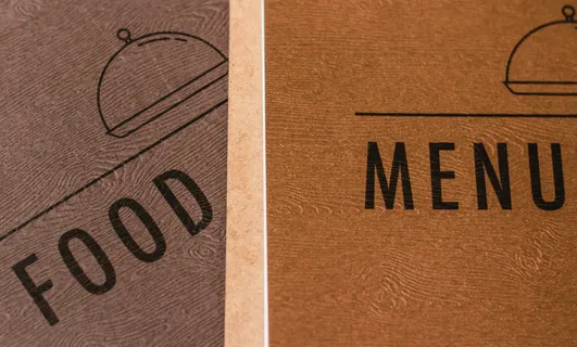 Two menus overlapping, one saying food, one saying menu, in two shades of a brown wood effect