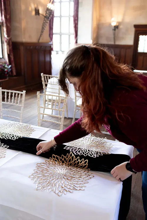 Rachel adjusting a black table runner on a white cloth
