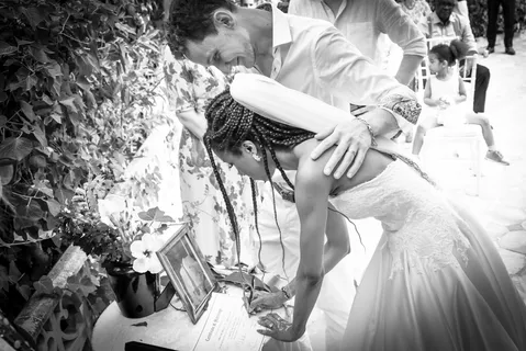 A black and white image of a newly married couple signing their certificate of marriage